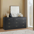 Black dresser with gold handles in a room with a painting and decor items.