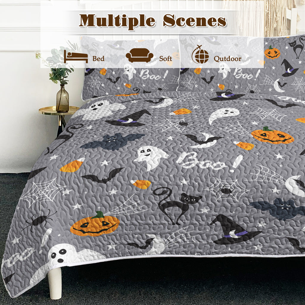 Halloween-themed bedspread with ghosts, pumpkins, and witches' hats on a gray background.