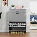 Gray shoe cabinet with multiple pairs of shoes on a wooden floor.