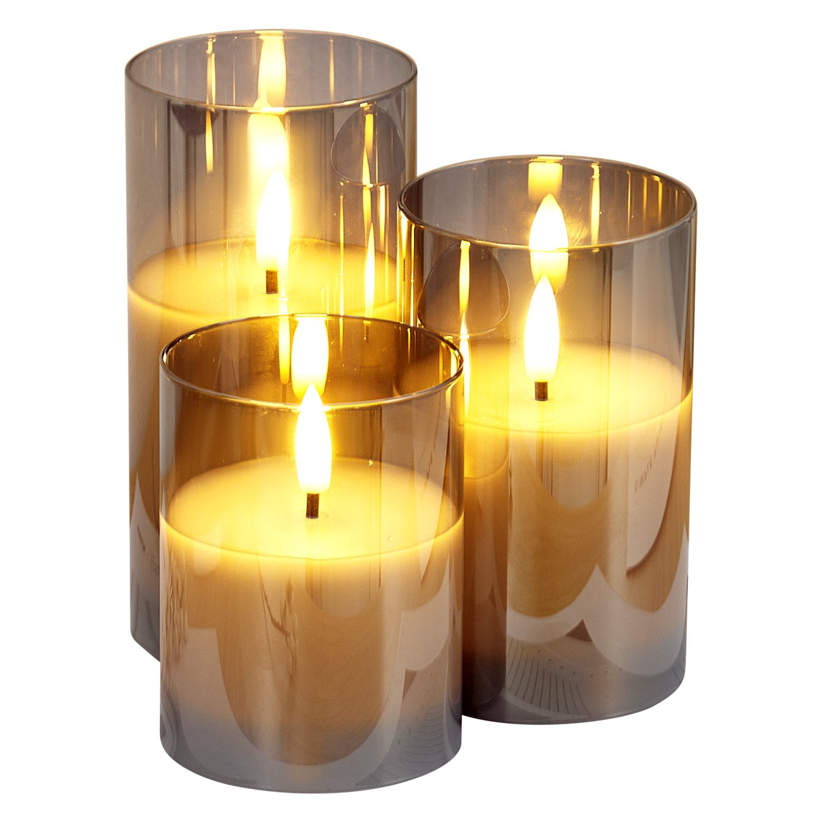 Three cylindrical glass candle holders with lit candles inside on a white background