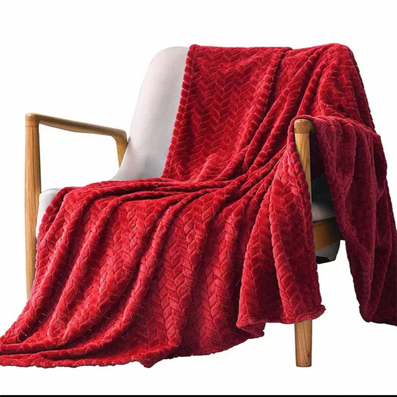 Red textured blanket draped over a white chair on a white background