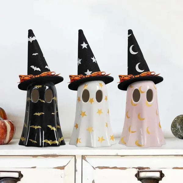 Three Halloween-themed ghost figurines with witch hats on a shelf.