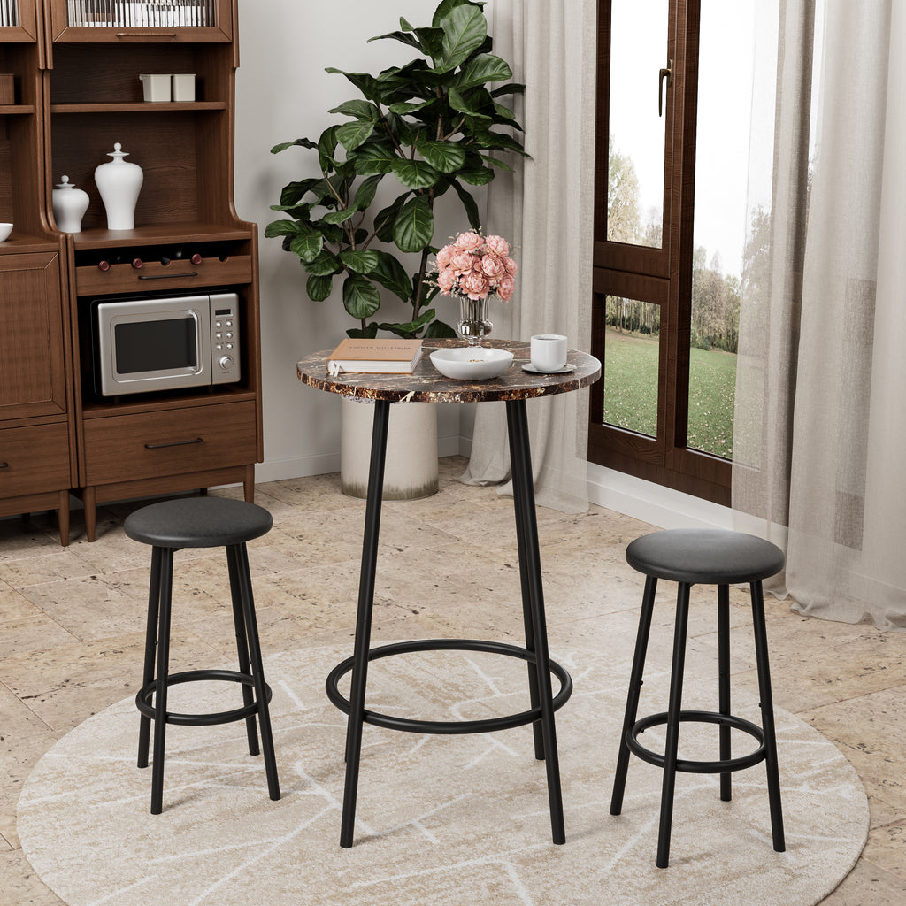 3-piece counter-height pub set with marble-look round table and two black cushioned stools in a bright living space