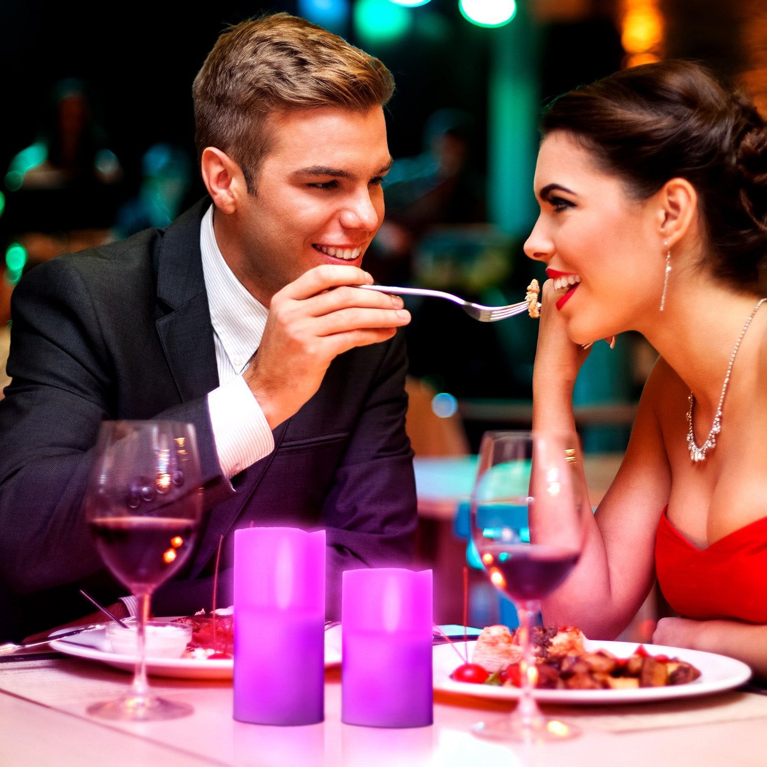 Man and woman sharing a romantic dinner with wine glasses and candles.
