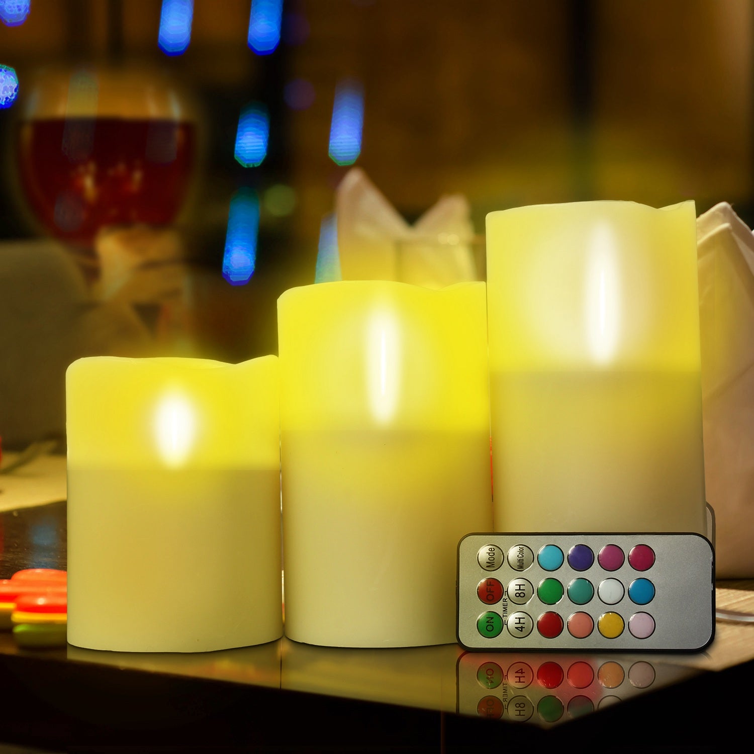 Set of LED candles with a remote control on a reflective surface, blurred background