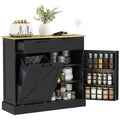 Black kitchen cabinet with open door displaying jars and a countertop with kitchen items.