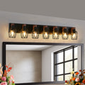Modern wall-mounted mirror with decorative lights on a neutral wall.