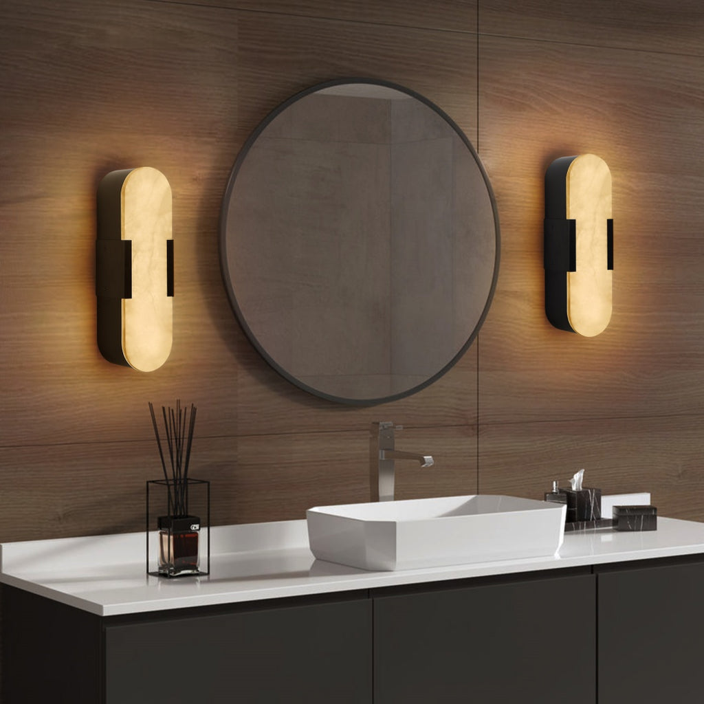Bathroom vanity with round mirror, lights, and white countertop.