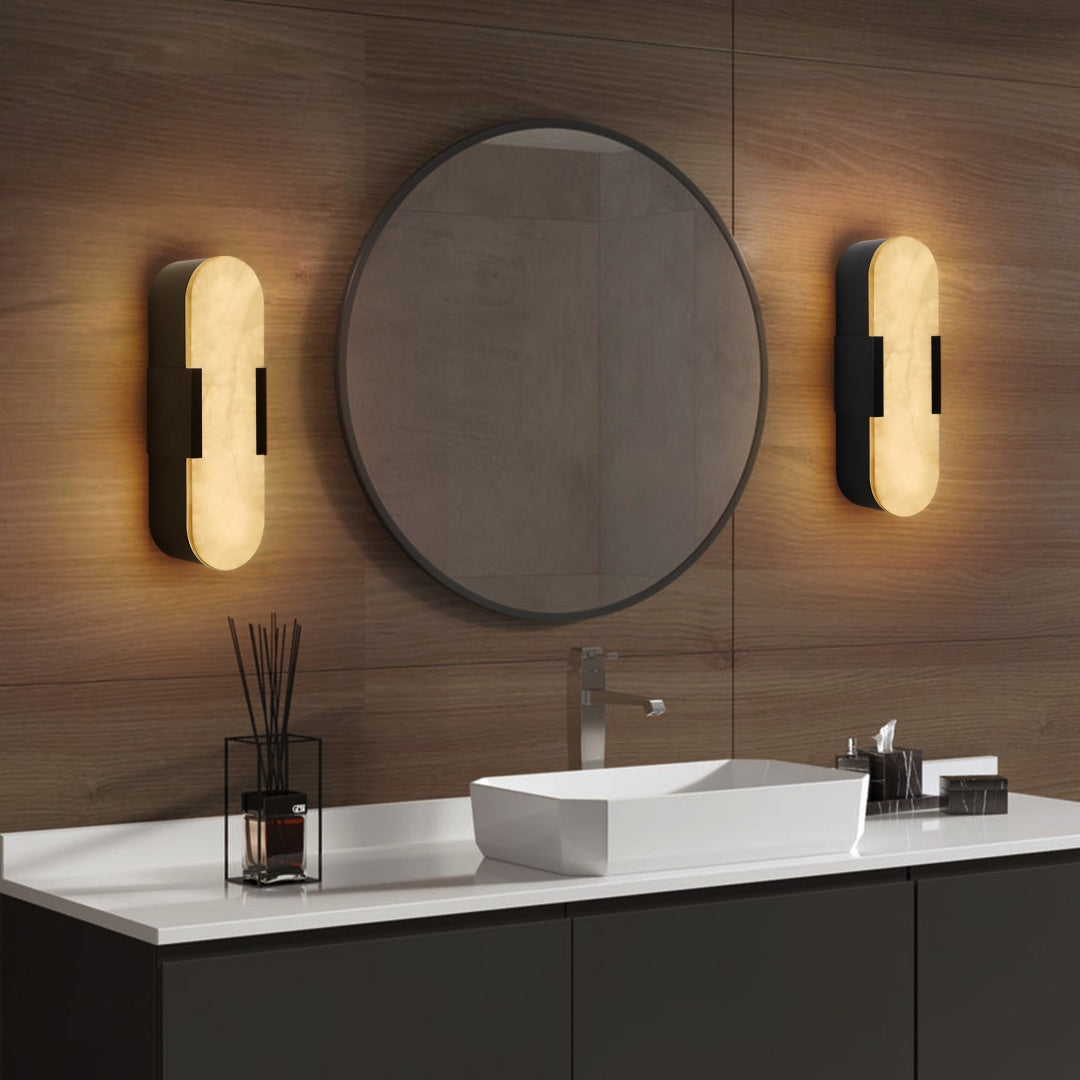 Bathroom vanity with round mirror, lights, and white countertop.