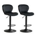 Two black swivel bar stools with cushioned seats positioned at a modern kitchen island with wood cabinetry