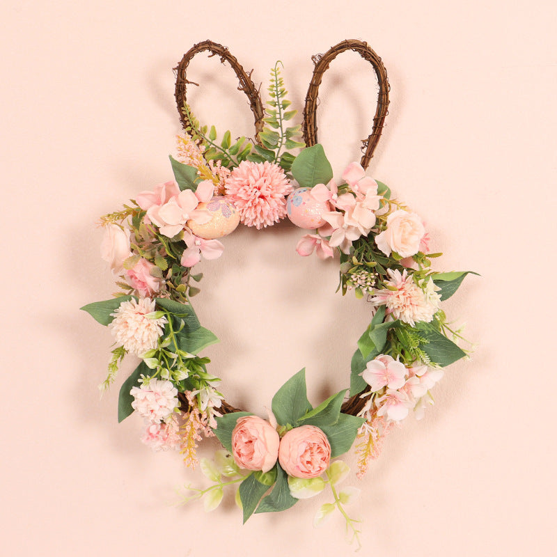 Floral wreath with pink flowers and green leaves on a light pink background