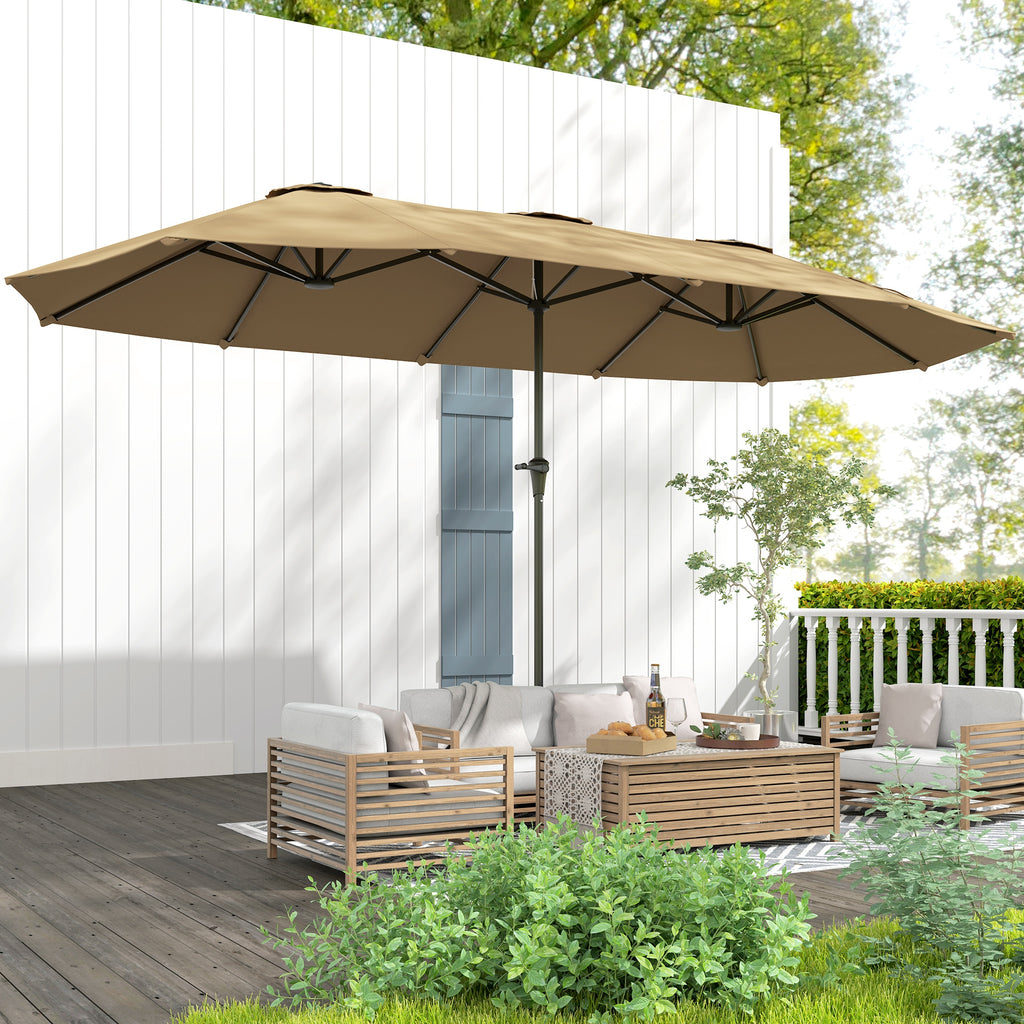 Beige patio umbrella over outdoor furniture set with a white wall and greenery in the background