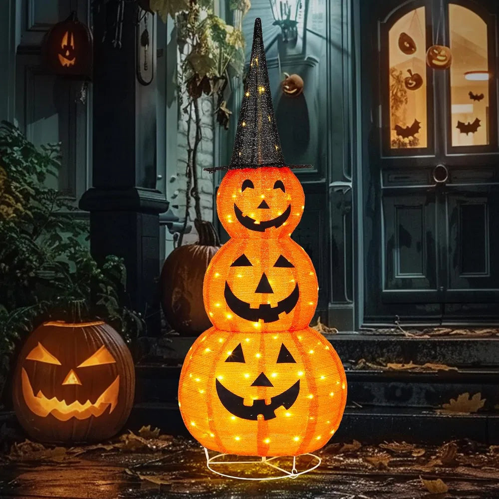 Stacked illuminated Halloween pumpkins with a dark door and window with pumpkin carvings in the background.