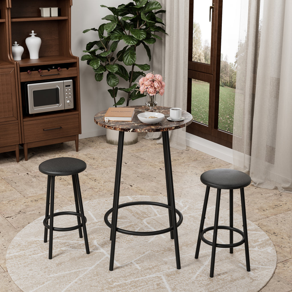 3-piece counter-height pub set with marble-look round table and two black cushioned stools in a bright living space