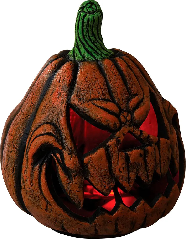 Decorative pumpkin with a carved face and glowing red interior on a white background