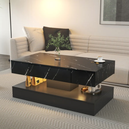 Modern black marble coffee table in a living room setting with a couch and decorative items.