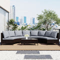 Outdoor patio set with gray cushions on a wooden deck, city skyline in the background