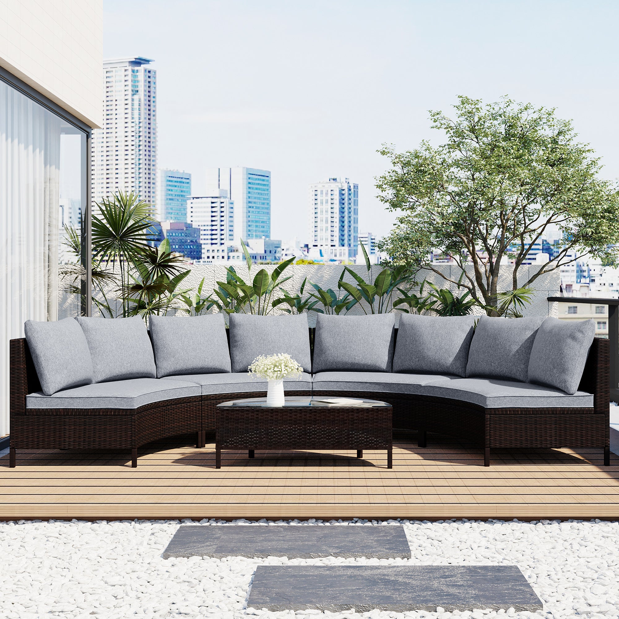 Outdoor patio set with gray cushions on a wooden deck, city skyline in the background