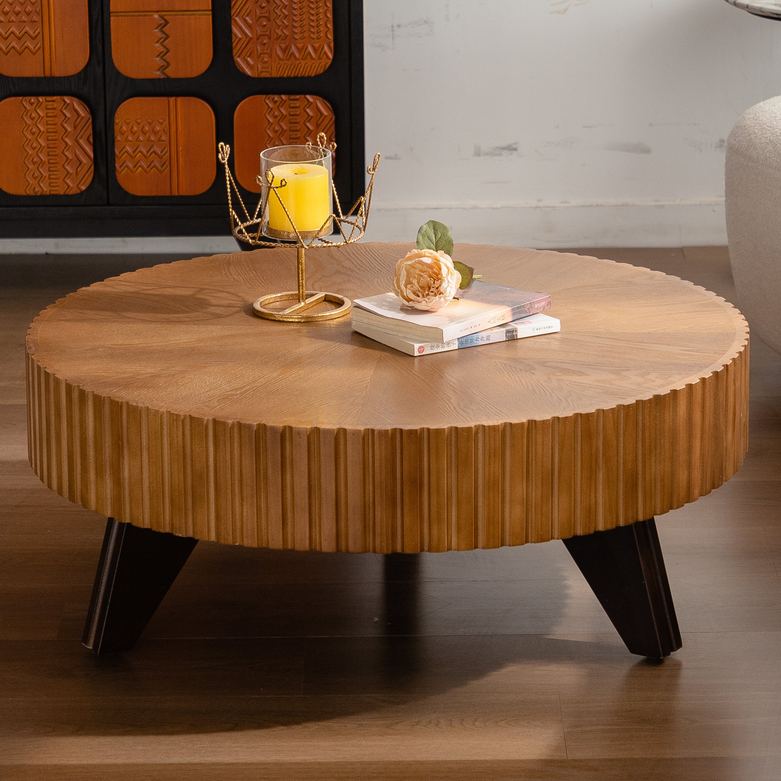 Round wooden coffee table with decorative items in a room setting