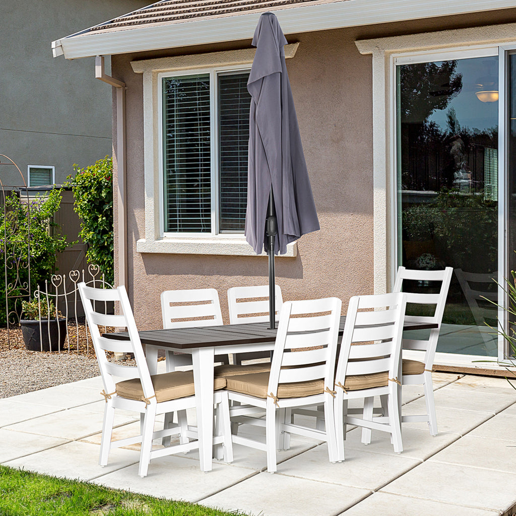 Outdoor patio set with table and chairs on a patio area in front of a house.
