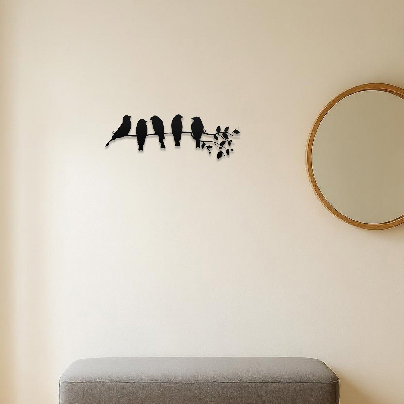 Decorative wall sticker of birds on a branch above a bench in a room.