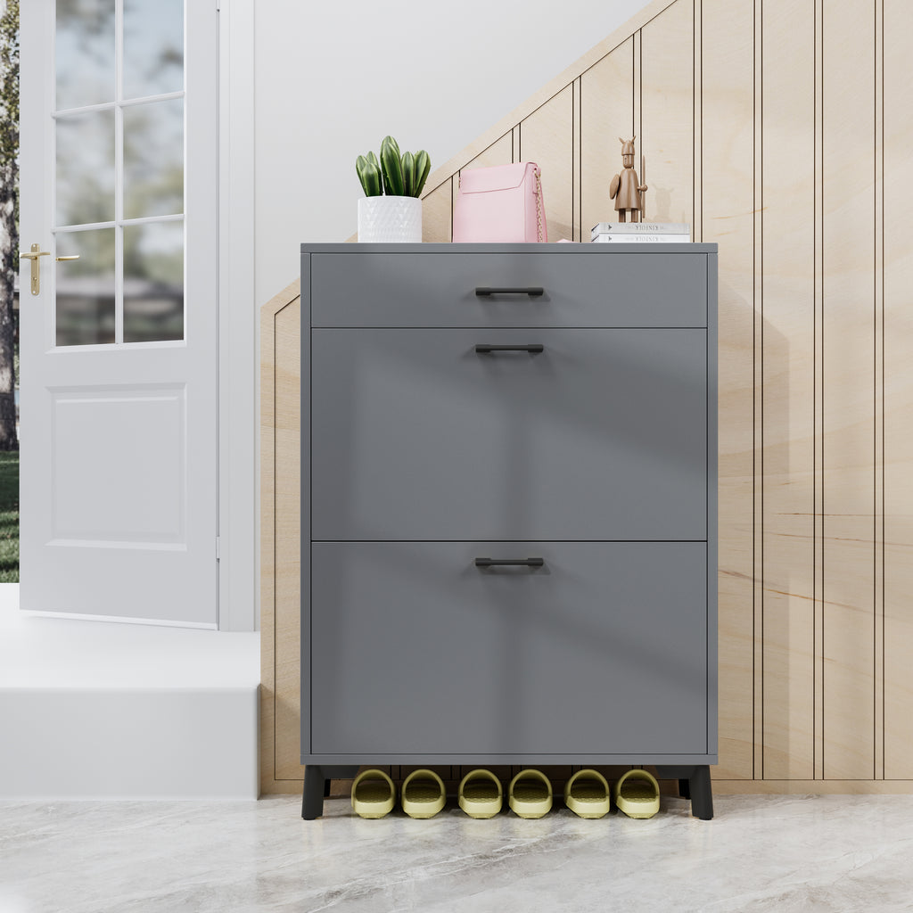 Gray shoe cabinet with drawers in a room with a white door and wooden wall.