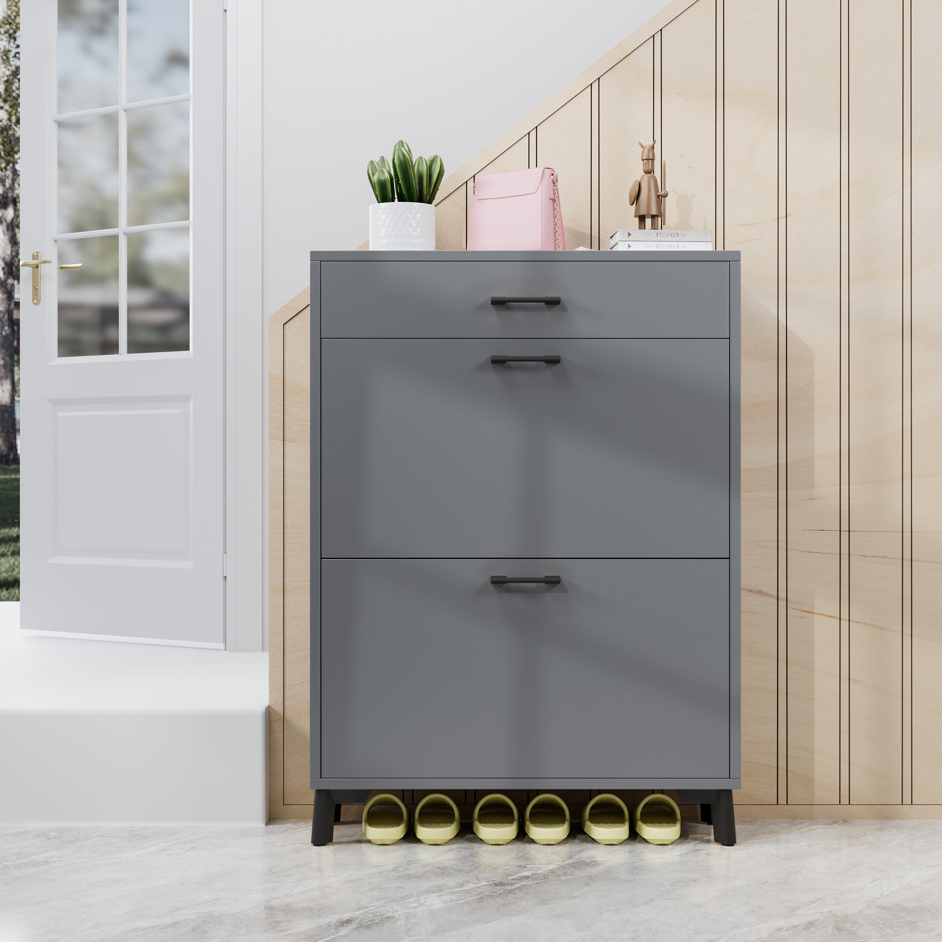 Gray shoe cabinet with drawers in a room with a white door and wooden wall.