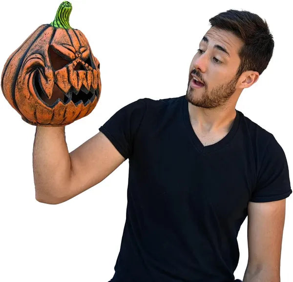 Man holding a carved pumpkin against a white background