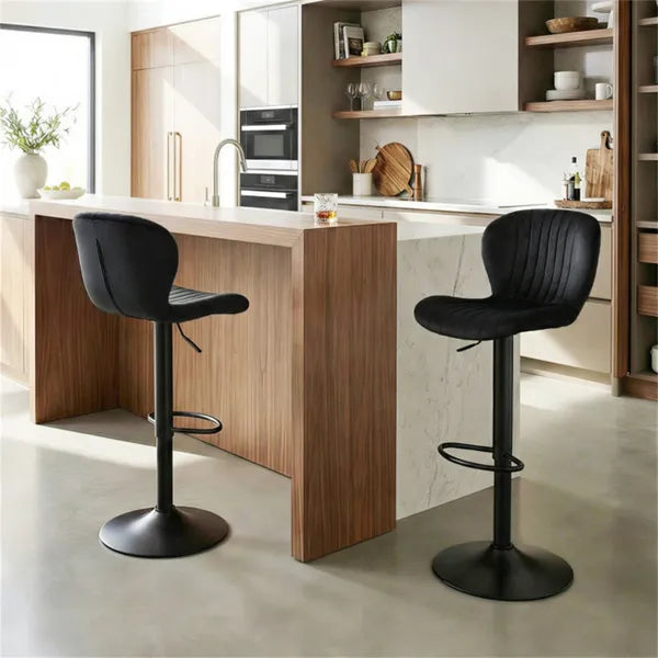 Two black swivel bar stools with cushioned seats positioned at a modern kitchen island with wood cabinetry
