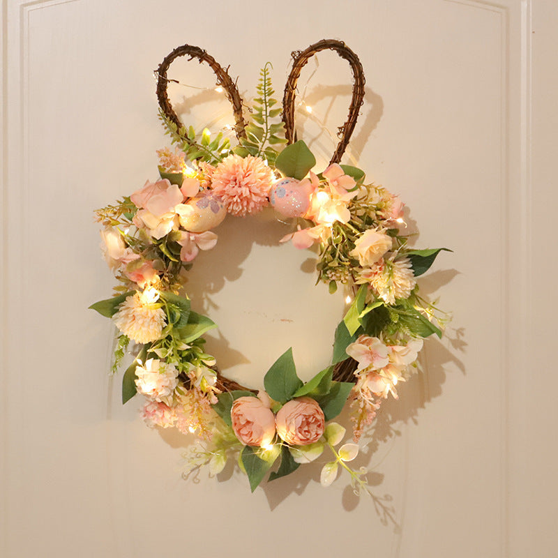 Decorative wreath with floral elements and bunny ears on a white door.