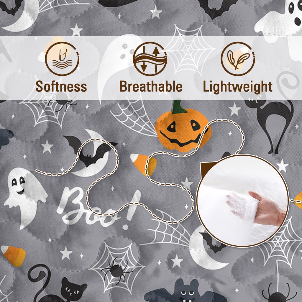 Halloween-themed fabric with ghost, pumpkin, and spider web patterns on a gray background.