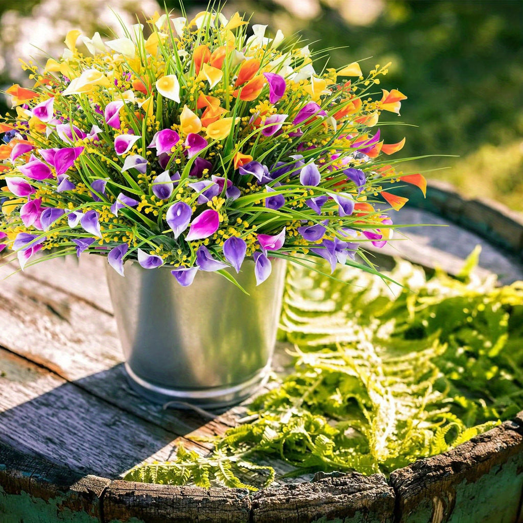 Colorful bouquet of flowers in a metal container on a wooden surface with greenery in the background