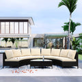 Outdoor patio furniture set with beige cushions on a patio with a modern house and palm trees in the background.