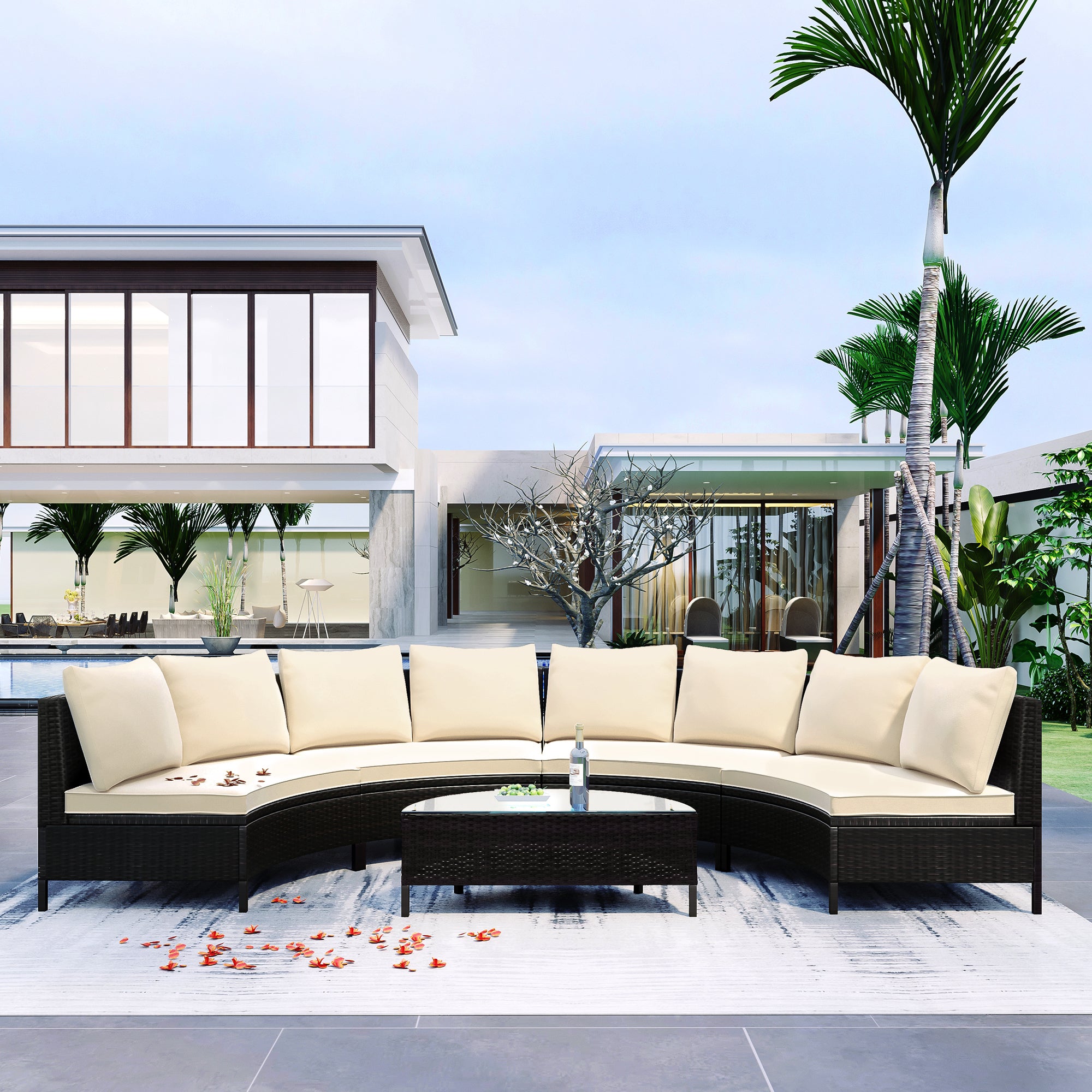 Outdoor patio furniture set with beige cushions on a patio with a modern house and palm trees in the background.