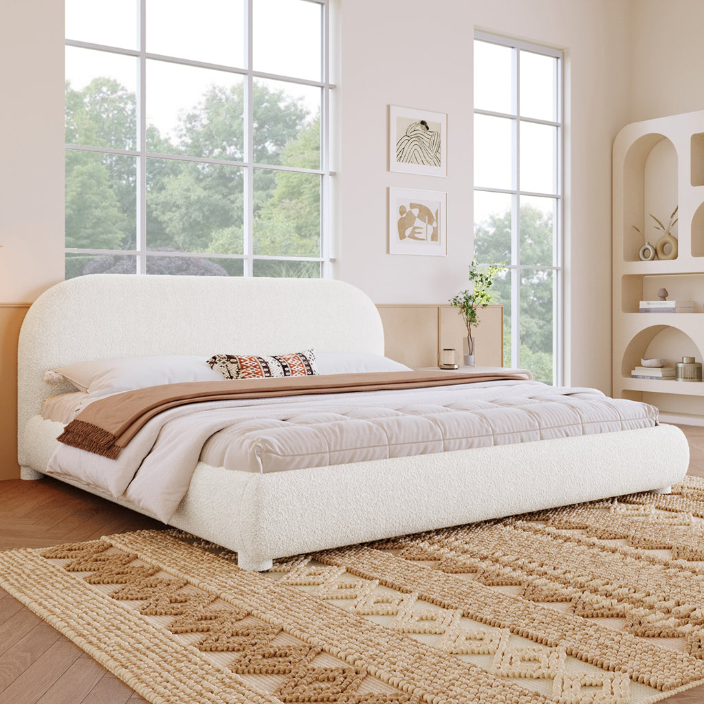 Modern bedroom with a large bed, windows, and decorative elements.