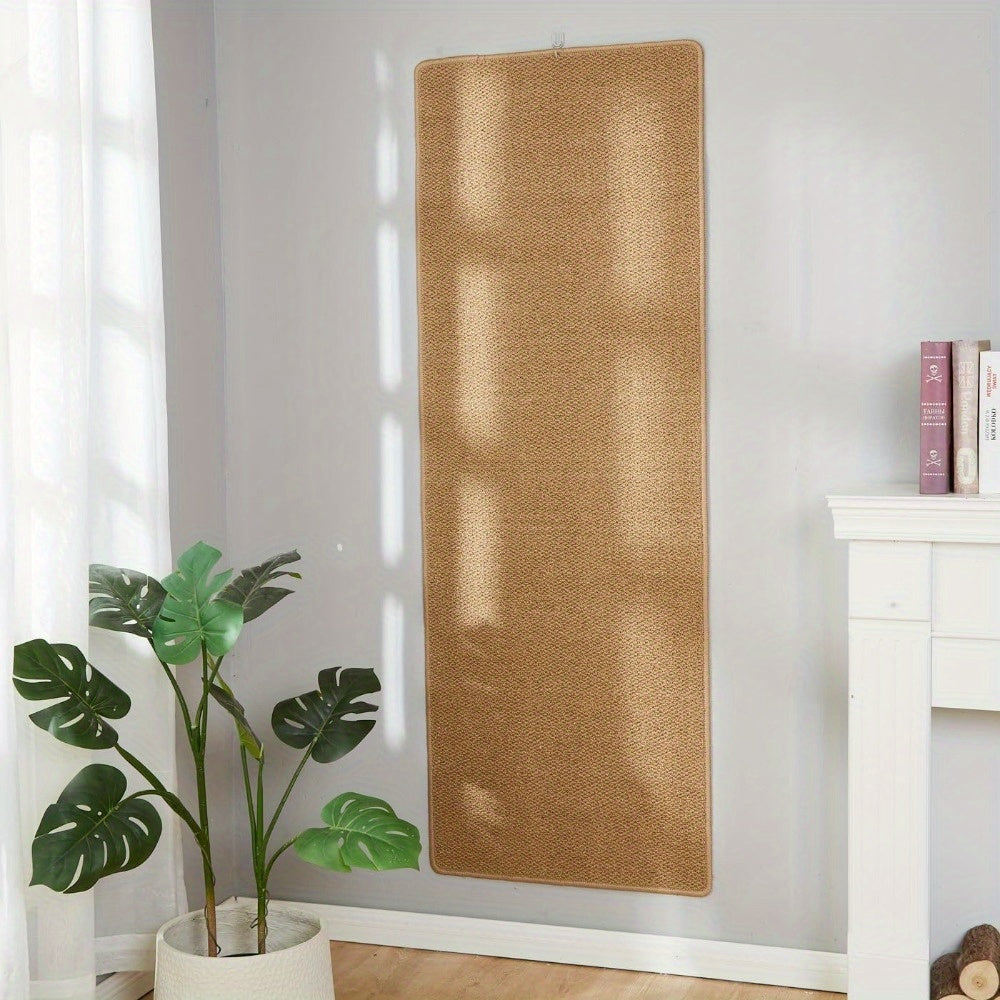 Brown woven blind hanging on a white wall with a plant and books in the foreground.
