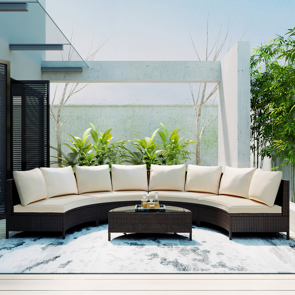 Outdoor patio set with curved sofa and coffee table in a modern garden setting.