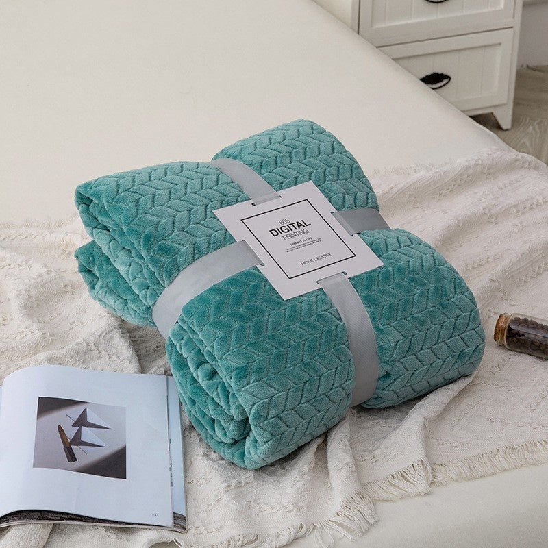 Teal blanket with a tag on a white bed