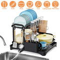 Dish drying rack with various dishes and utensils next to a sink.