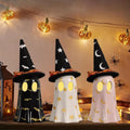 Three Halloween-themed ghost lights with witch hats on a decorative setup.
