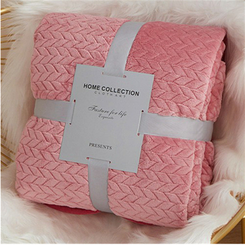 Pink textured blanket with a label on a fluffy white surface