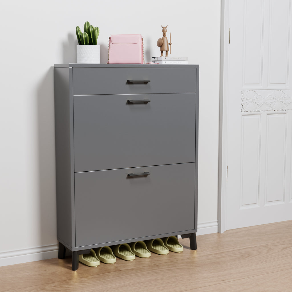 Gray shoe cabinet with three drawers and a small shelf on top, featuring decorative items.