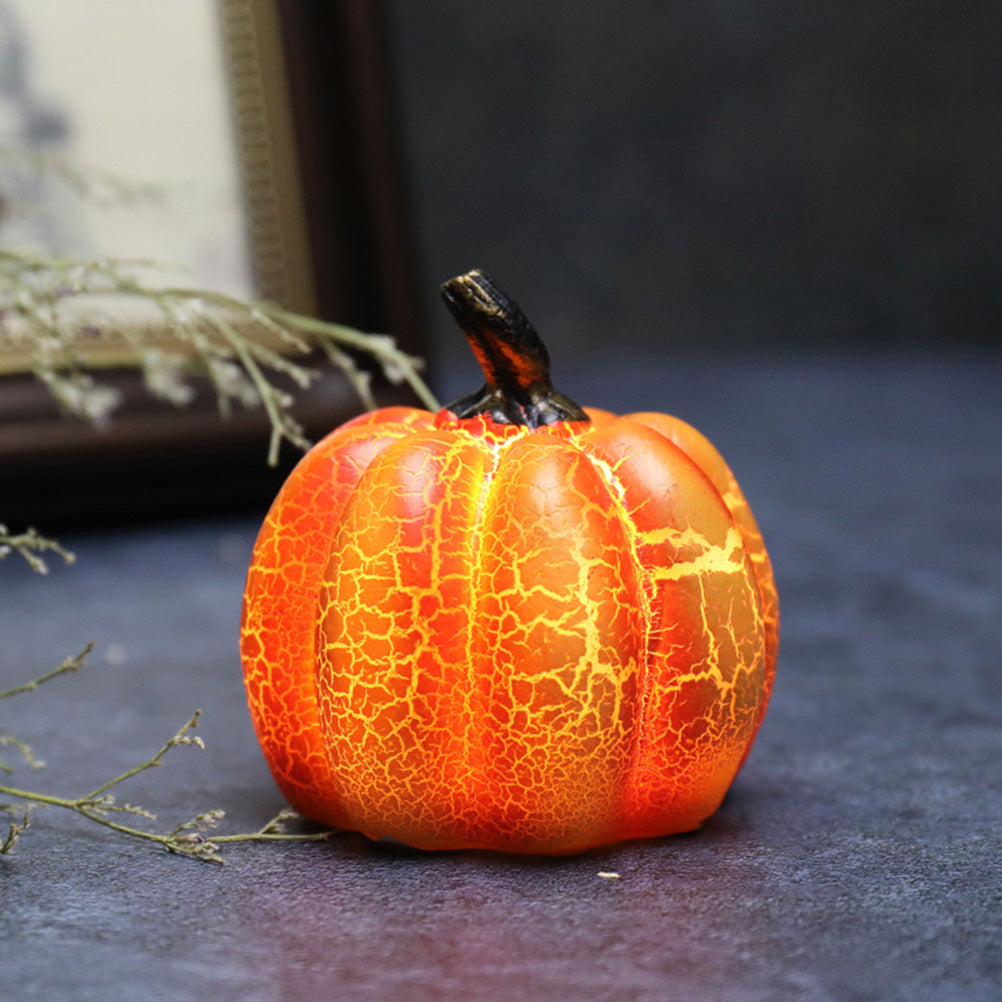 Small orange pumpkin with a cracked texture on a dark surface