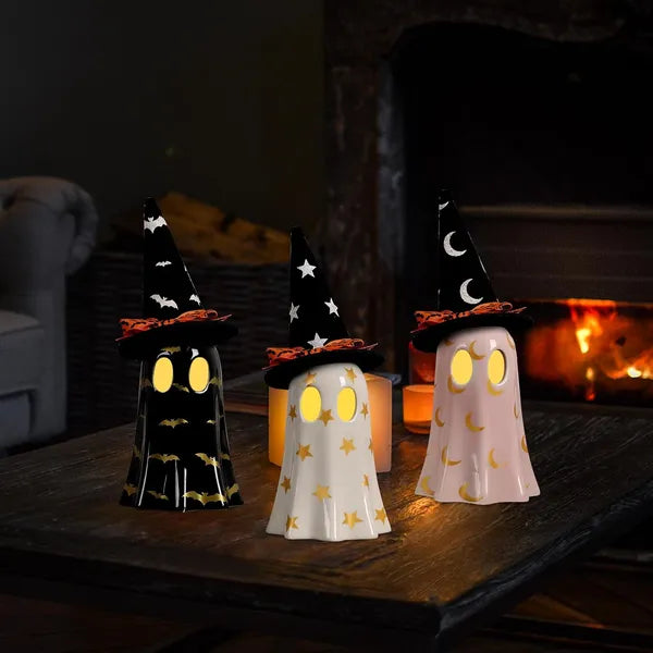 Halloween-themed decorative lights with witch hats on a wooden surface.