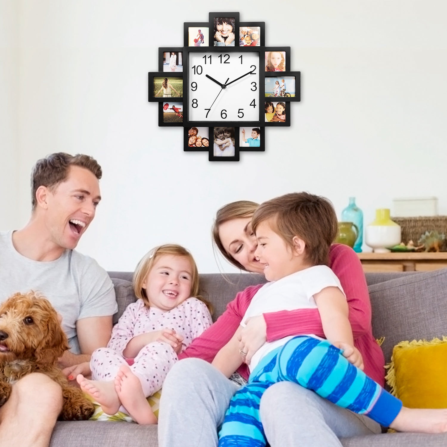 Family sitting on a couch with a wall clock displaying family photos in a living room.
