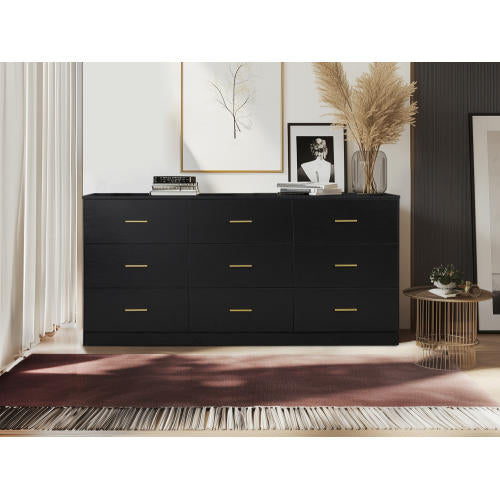 Black dresser with gold handles in a room with decor elements.