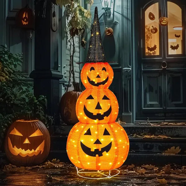 Stacked Halloween pumpkin lights with glowing faces in front of a house entrance.